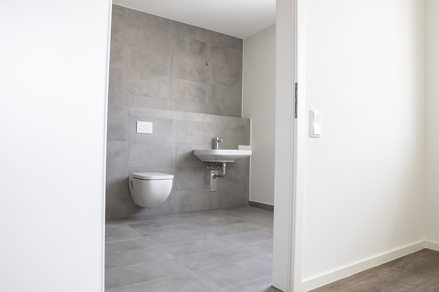 Barrierefreies Bad mit schwellenlosem Zugang, wandhängendem WC und unterfahrbarem Waschbecken